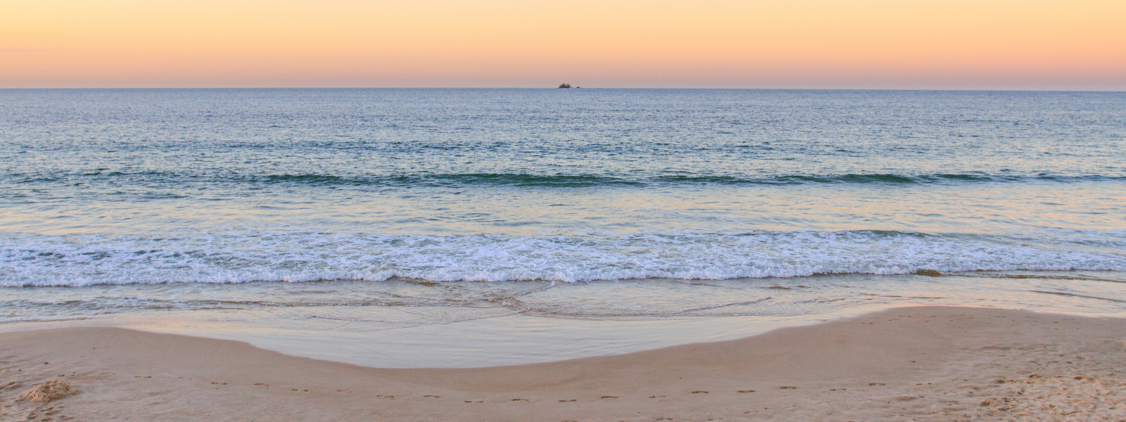 The file shows a Hawaiian sunset over the ocean. The sky is a mix of warm oranges and pinks as the sun sets. The calm ocean reflects these colors, creating a serene, picturesque scene with no land or other elements visible.